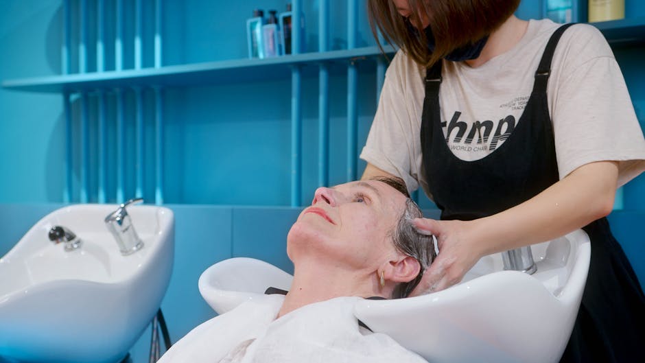 An elderly woman enjoys a professional hair wash at a modern hair salon
